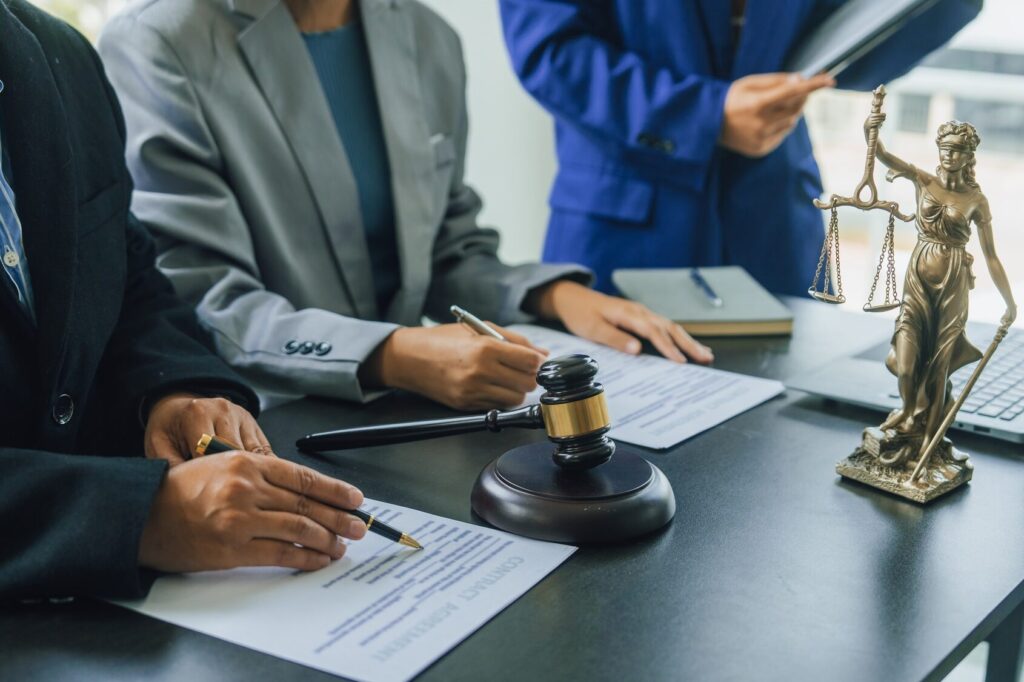 Business lawyer team working with law firms contracts in working room.